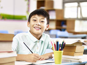 亚洲小学男生在教室里做作