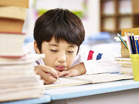 感到厌烦的亚洲男学生在教室里做作