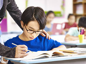 亚洲小学学生得到老师的帮助图片