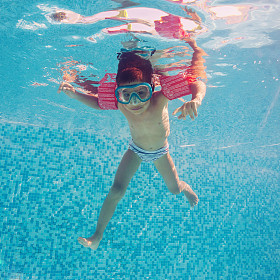 水下的小孩在游泳池与麝香和扶手