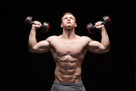 英俊的权力人健身模型与六包是训练与哑铃,与 copyspace 的黑色背景上孤立