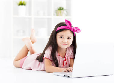 快乐的小女孩，使用一台笔记本电脑