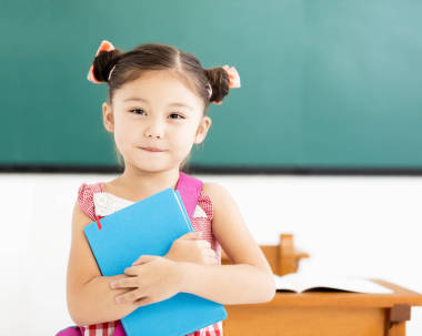 快樂的小女孩舉行書在教室里圖片