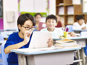 亚洲小学学生在课堂中使用平板电脑