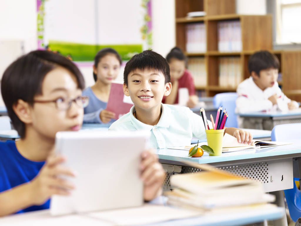 亚洲小学学生在课堂中使用平板电脑