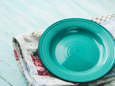 在老式餐巾木制带纹理的背景上的绿色板