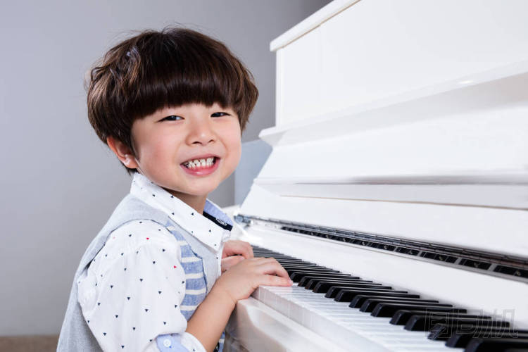 快樂(lè)亞洲中國(guó)小男孩在家里彈鋼琴