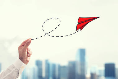 商人拿著一個小紙飛機圖片