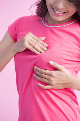 幸福的女人，检查她的胸部.图片