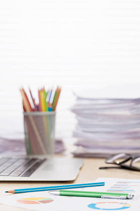 笔记本电脑、 报告和铅笔照片