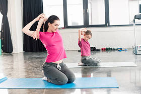 母亲和女儿坐在瑜伽垫上图片