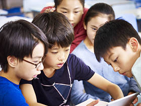 集团的亚洲学生一起使用平板电脑