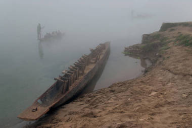 一國家木制尼泊爾，兩只獨(dú)木舟的倒立水箱站在岸邊，其他船只航行沿著河在霧中的，上午在尼泊爾奇特旺