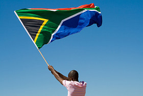 非洲男子挥舞着南非反对蓝蓝的天空