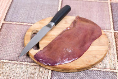 新鮮的生豬肉肝木制廚房用刀板上