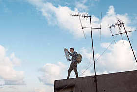 旅行者站在与手中的地图在城市屋顶的边缘