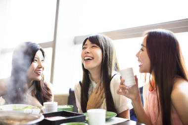 快樂的年輕婦女組吃火鍋圖片