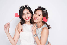 两个女孩拿着纸做的爱心图片