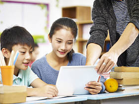 亚洲的小学生使用数字平板电脑在教室里了
