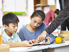 亚洲的小学生使用数字平板电脑在教室里了