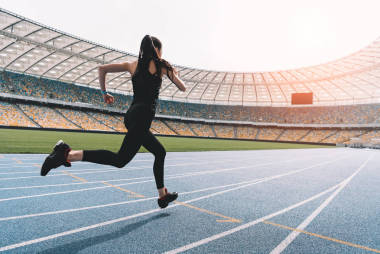 女運動員在球場上運行 圖片