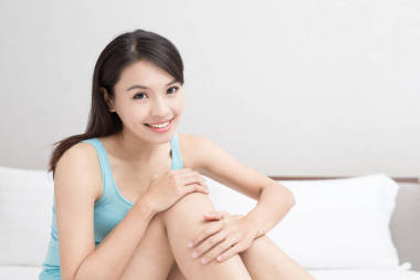 美麗的女人，在床上微笑 