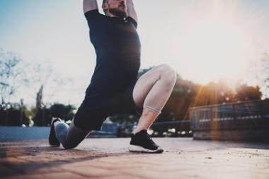 年輕人做伸展鍛煉肌肉訓(xùn)練前。鍛煉的生活方式的概念。在陽光明媚的公園戶外運(yùn)動的肌肉運(yùn)動員。模糊的背景