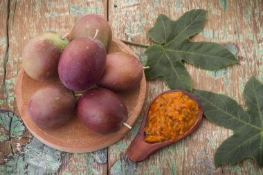 百香果和它的果肉在木制的背景下,原产于美国南部的水果 百香果和它的果肉在木制的背景下,原产于美国南部的水果