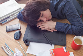 设计师的女孩可悲的被靠在图形平板表