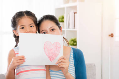 美丽的母亲和青年女儿，拿着一张卡片