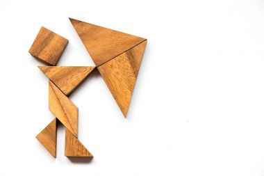 作為男人的木質(zhì)七巧板舉行傘形狀在白色背景上 （作為業(yè)務(wù)概念有危機(jī))