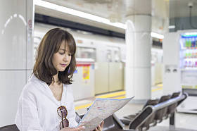 愉快的亚洲商业女人室内看市地图