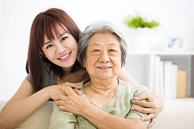 祖母和孙女。年轻女人仔细照顾的老女人