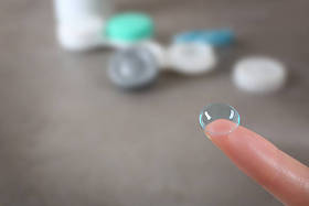 女性的手指上隐形眼镜