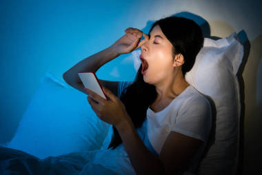 使用手機擦她的眼睛，打呵欠的女人