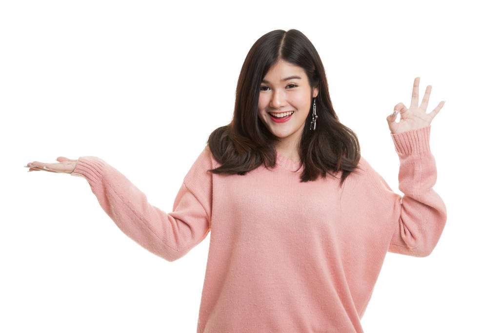 美丽的年轻亚洲女子显示棕榈手和 Ok 的手势