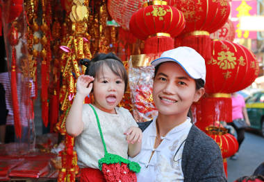 中國農(nóng)歷新年春節(jié)在唐人街在曼谷，泰國亞洲女人和她的女兒在中國服飾對(duì)傳統(tǒng)中國紅裝飾是很受歡迎