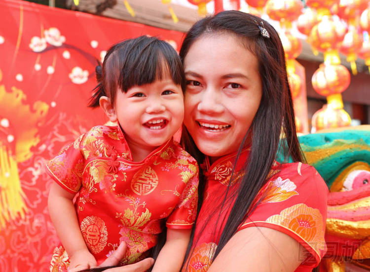 春節(jié)快樂，可愛的亞洲女孩微笑和擁抱她的孩子在傳統(tǒng)中國服飾