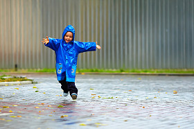 开心宝贝男孩运行的街头、 多雨的天气
