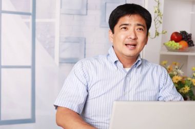 亞洲人使用一臺(tái)筆記本電腦圖片