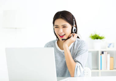 在視頻通話談線耳機(jī)與筆記本電腦的年輕女子