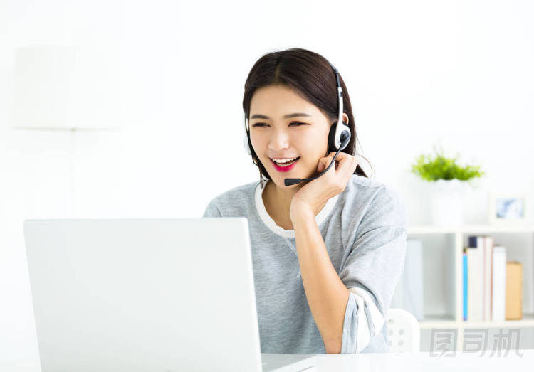 在視頻通話(huà)談線(xiàn)耳機(jī)與筆記本電腦的年輕女子