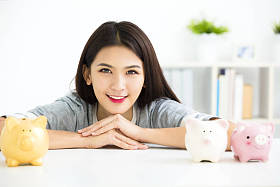 微笑的年轻女子和储钱罐图片