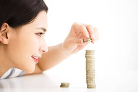 年轻女人把硬币栈，节省金钱