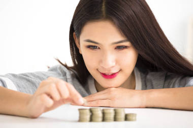 年輕女人把硬幣棧，節(jié)省金錢