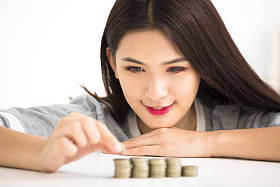 年轻女人把硬币栈，节省金钱