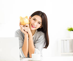 微笑的年轻女子捧着存钱罐图片