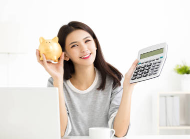 显示计算器和储钱的年轻女人图片