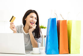 年轻女人显示信用卡和购物的车床