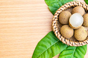 鲜龙眼龙眼叶木桌上设置图片